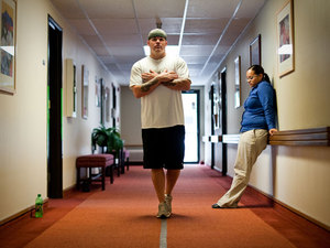 Brandon Sanford performs balance exercises at Mentis while physical therapist watches